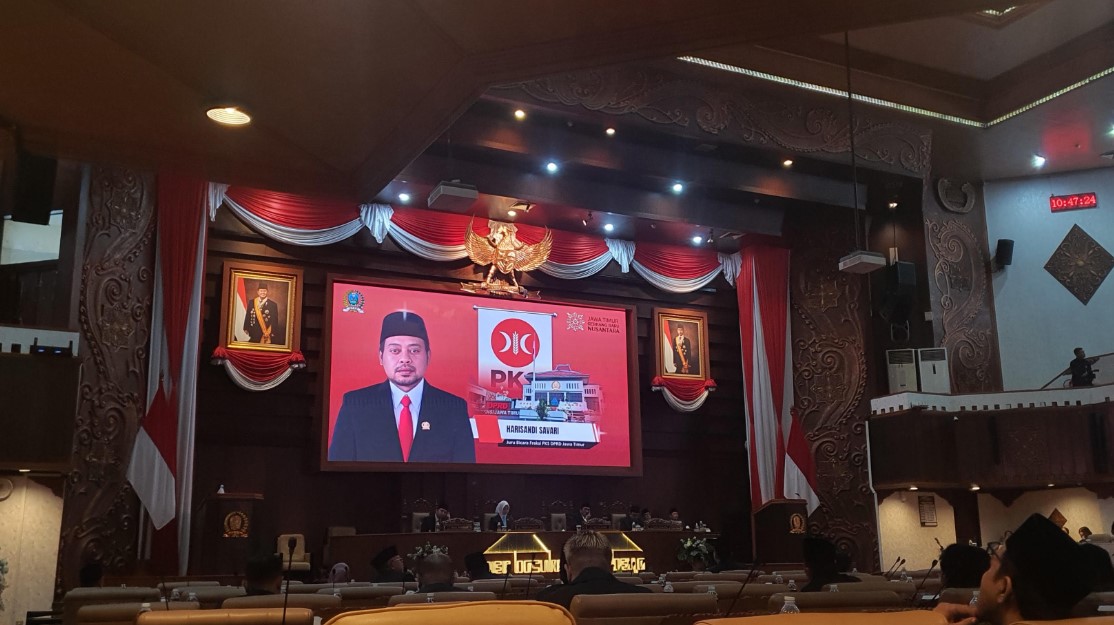 Layar menampilkan Harisandi Savari, Juru Bicara Fraksi PKS DPRD Jatim, saat menyampaikan Pandangan Umum Fraksinya dalam rapat paripurna.