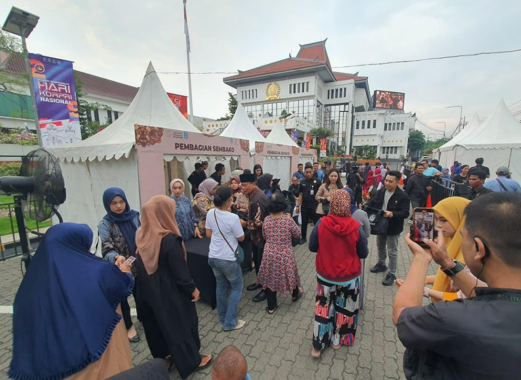 Erick Komala menyerahkan paket sembako kepada warga di halaman DPRD Jawa Timur.