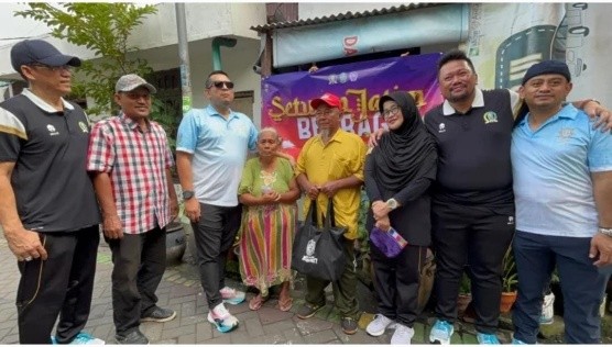 Kepala Bagian Persidangan dan Perundang-undangan Sekretariat DPRD Jawa Timur Syamsiar Aulia Rahman saat menyerahkan paket sembako kepada warga di sekitar Gedung DPRD Jatim, Surabaya